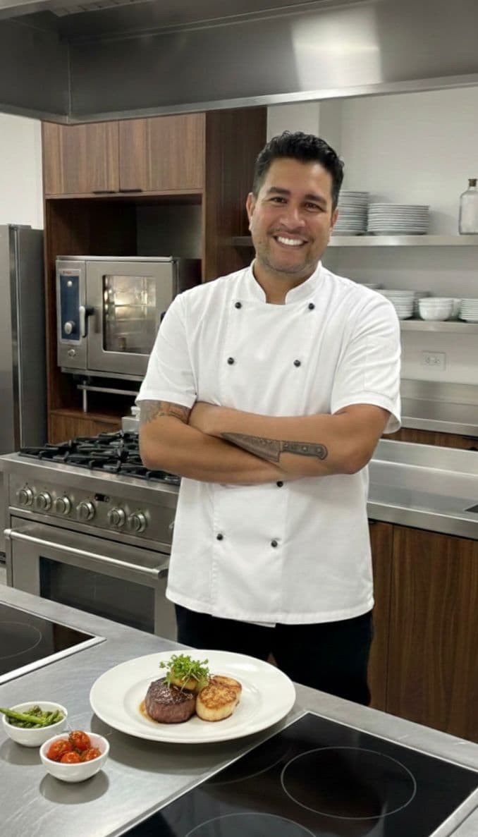 Chef Maycon Godoy em sua cozinha com prato de alta gastronomia